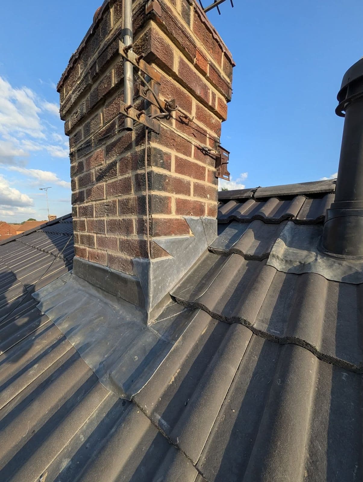 Chimney with new lead flashing on interlocking tiles